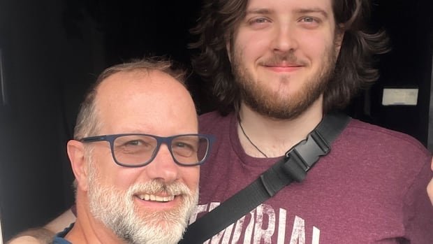 Two men in casual T-shirts smile for the camera.