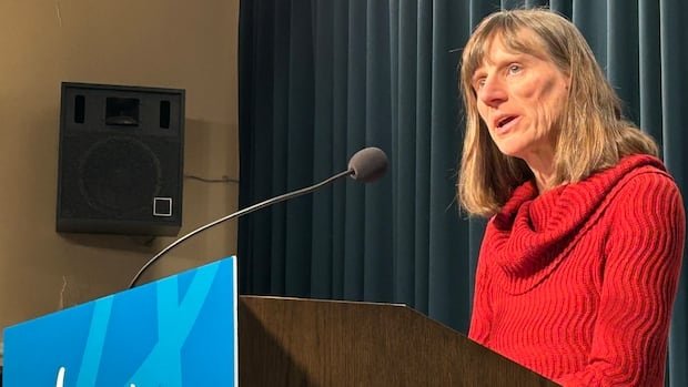 A woman speaks behind a podium.