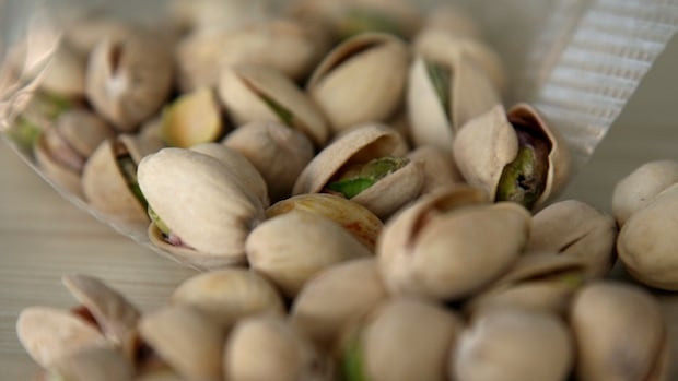 A bag of pistachio nuts with shells.