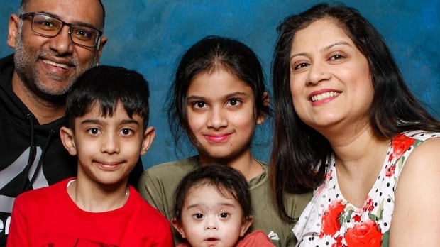 A family of five posing for the camera.