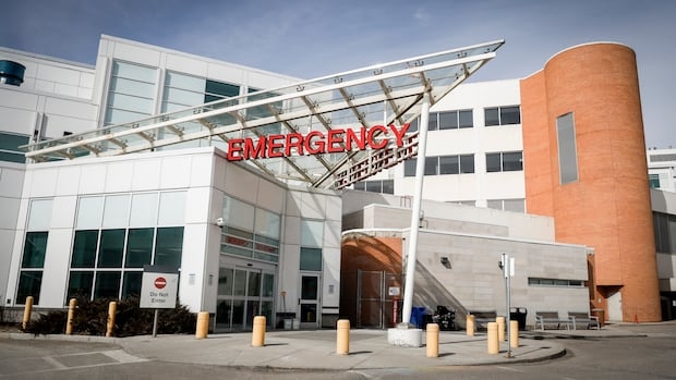 A red emergency sign sits on top of white building.