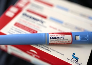 An image of a blue tube with an "Ozempic" label on it, sitting atop a red and white box.