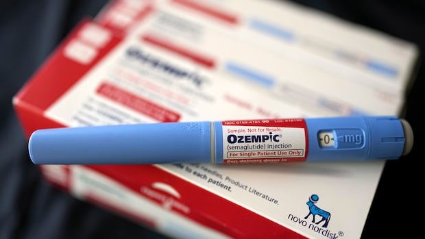 An image of a blue tube with an "Ozempic" label on it, sitting atop a red and white box.