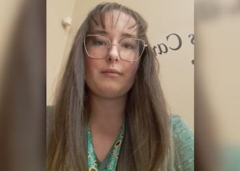 A woman is looking down and has a serious face.