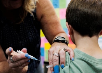 A child receives a dose of the Moderna coronavirus disease (COVID-19) vaccine at Skippack Pharmacy in Schwenksville, Pennsylvania, U.S. September 11, 2025.