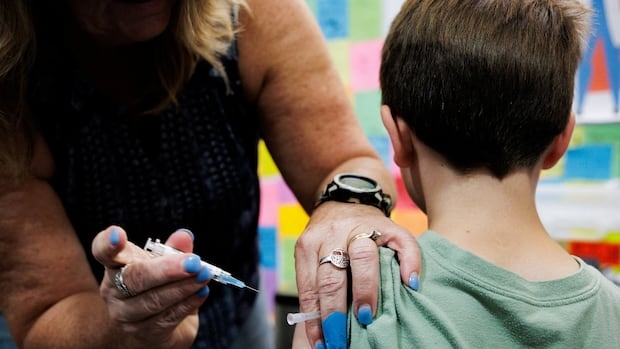 A child receives a dose of the Moderna coronavirus disease (COVID-19) vaccine at Skippack Pharmacy in Schwenksville, Pennsylvania, U.S. September 11, 2025.