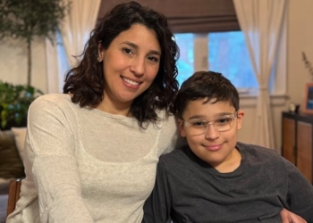 A mother and her son sitting together in their home.