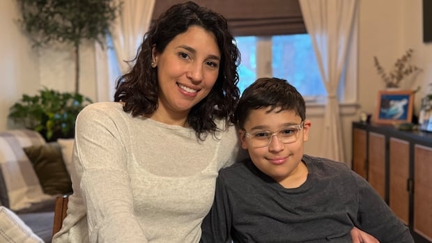 A mother and her son sitting together in their home.