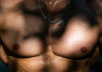 A man poses showing his muscled chest at Bercy street workout outdoor gym, in Paris, on August 10, 2025.