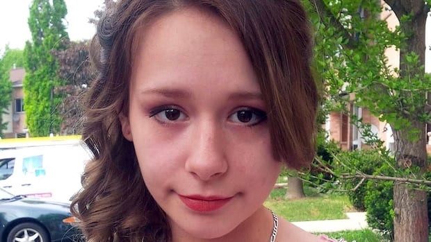 A young woman in a dress is seen.