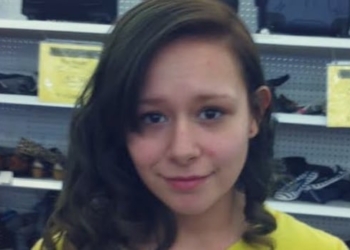 woman stands in store wearing yellow shirt