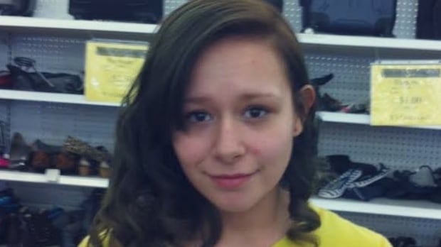 woman stands in store wearing yellow shirt