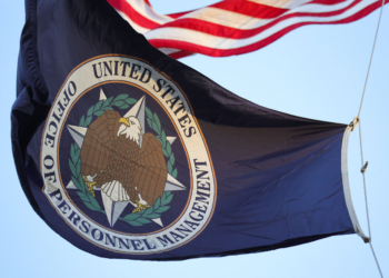 A flag with the seal of the Office of Personnel Management flies in the wind.