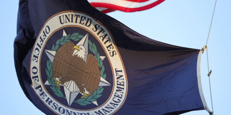 A flag with the seal of the Office of Personnel Management flies in the wind.