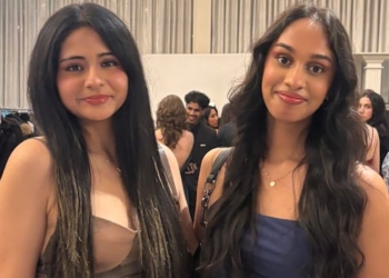 Two women stand side by side smiling.