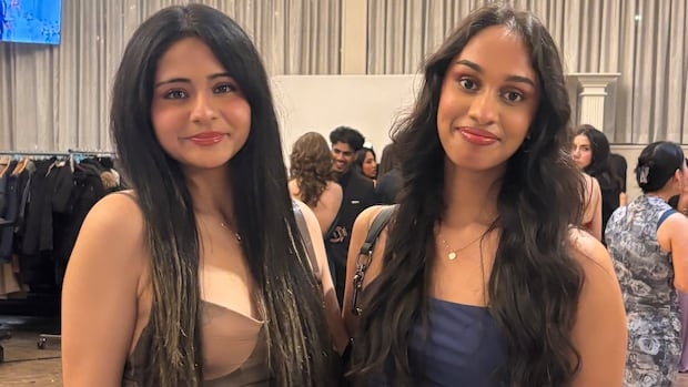Two women stand side by side smiling.