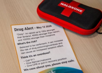 A naloxone kit is seen on a table with a piece of paper.
