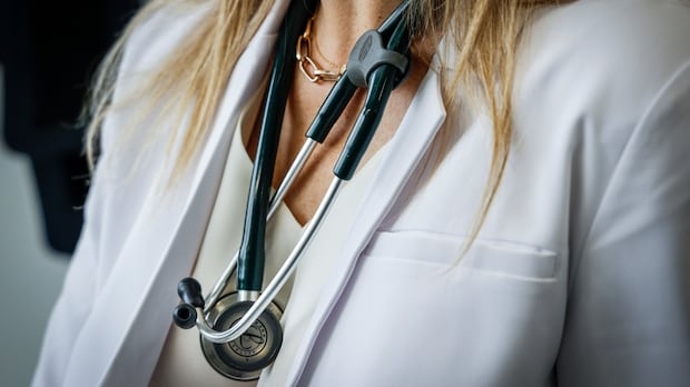 A stethoscope hangs around a female doctor's neck.