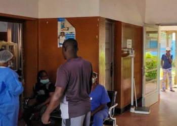 people in a hospital in PPE gather around each other