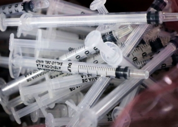 pile of single-use syringes for vaccines