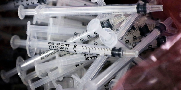 pile of single-use syringes for vaccines